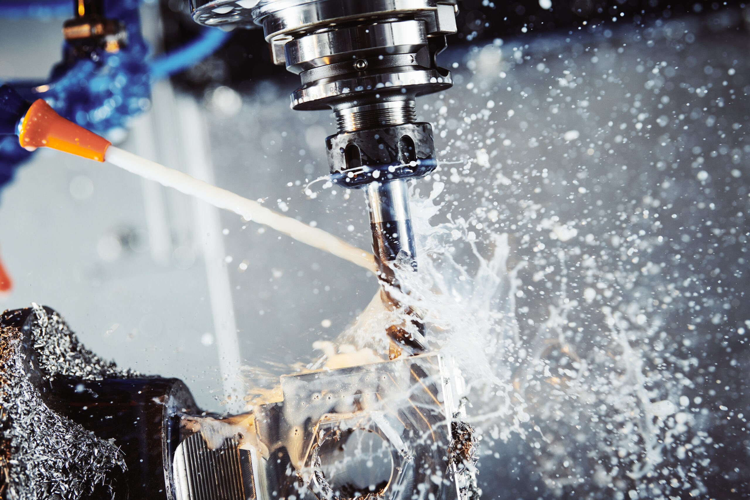 Industrial CNC metal machining by vertical mill. Coolant and lubrication