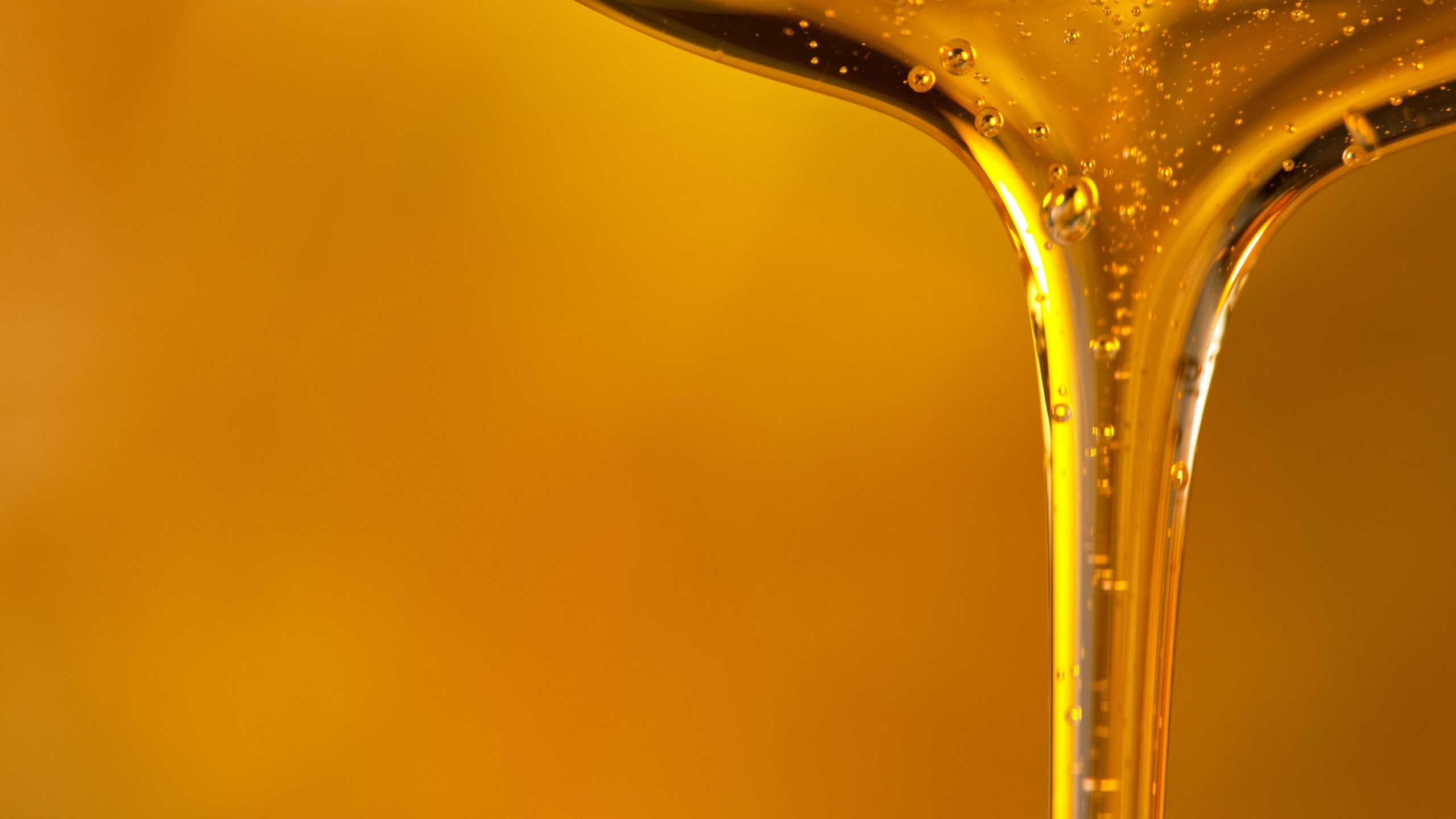 Industrial lubricant pouring with golden backdrop