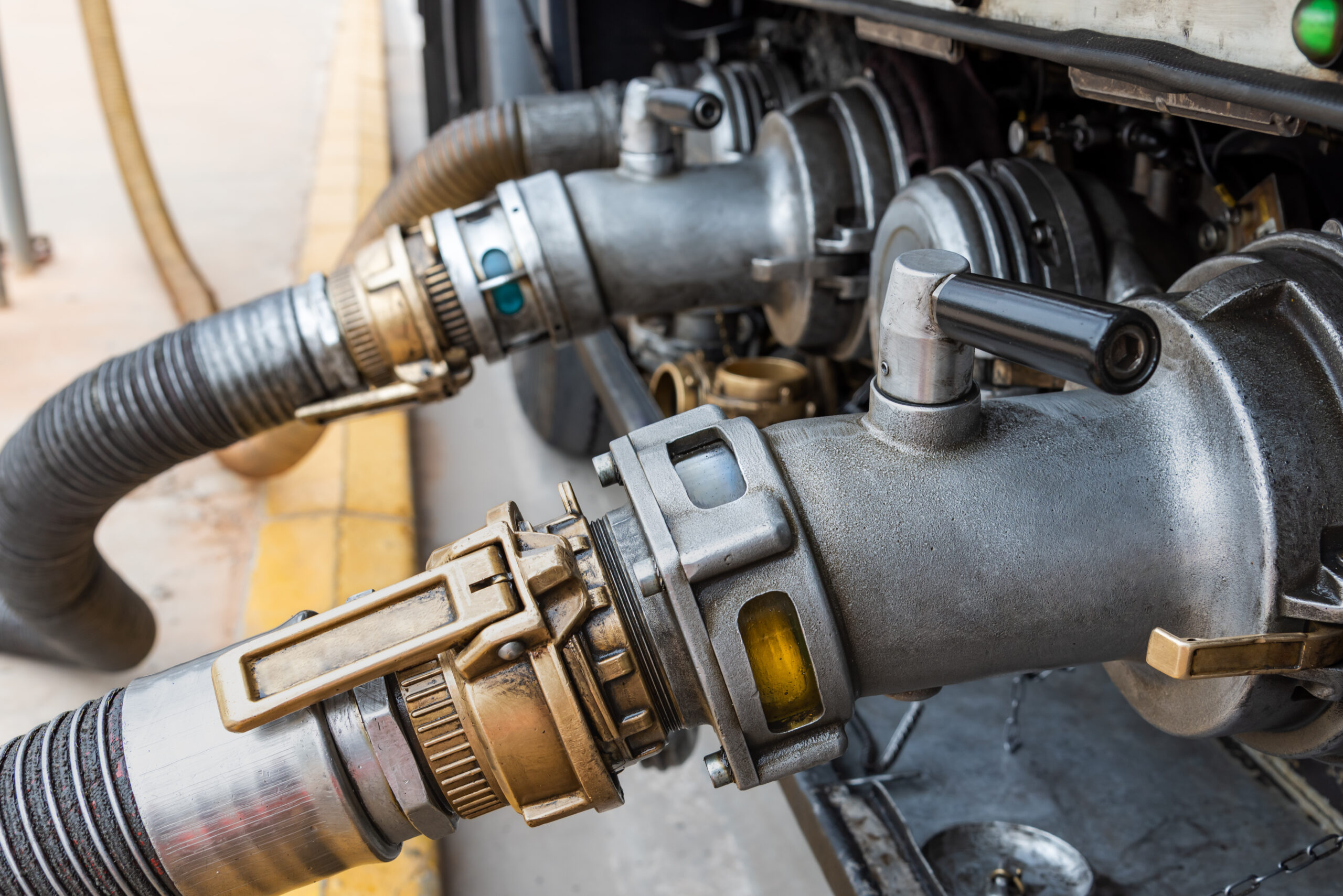 Mouths of a tanker truck connected to discharge hoses
